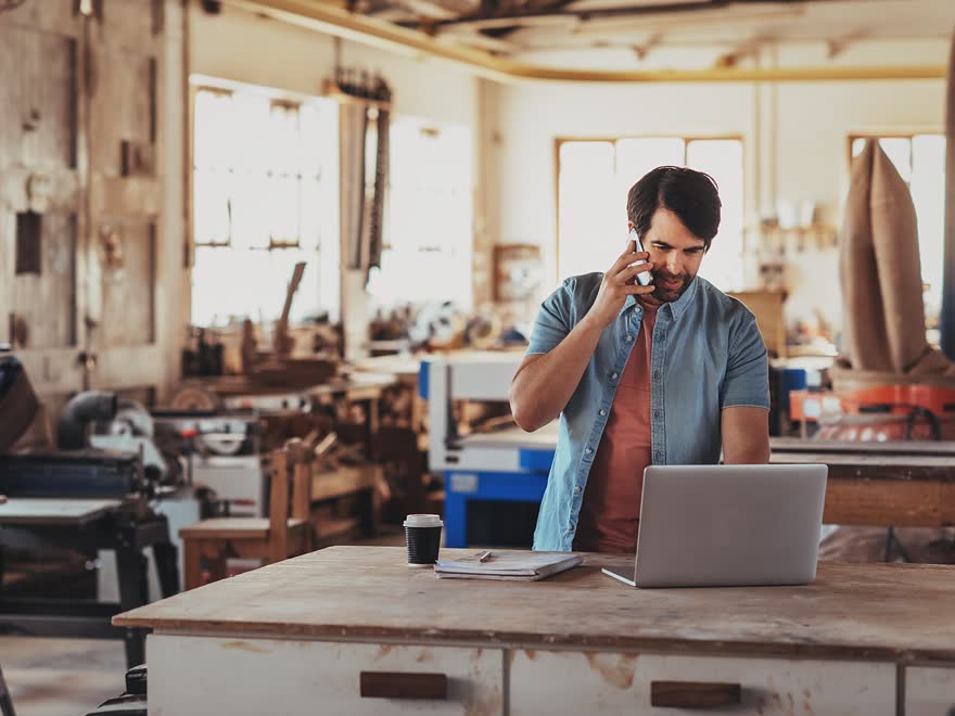 Person taking a call in a busy workshop workplace