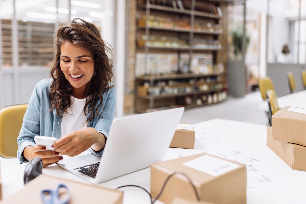 A small business owner reading a text message at her desk